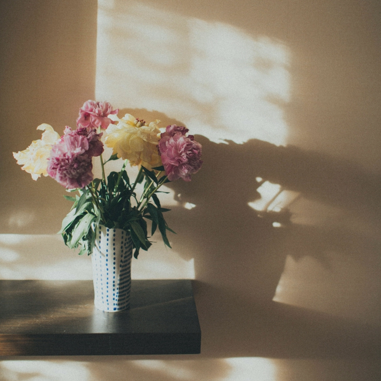 florero de cerámica con flores sobre estante