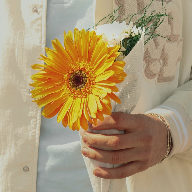 mano masculina con flor amarilla