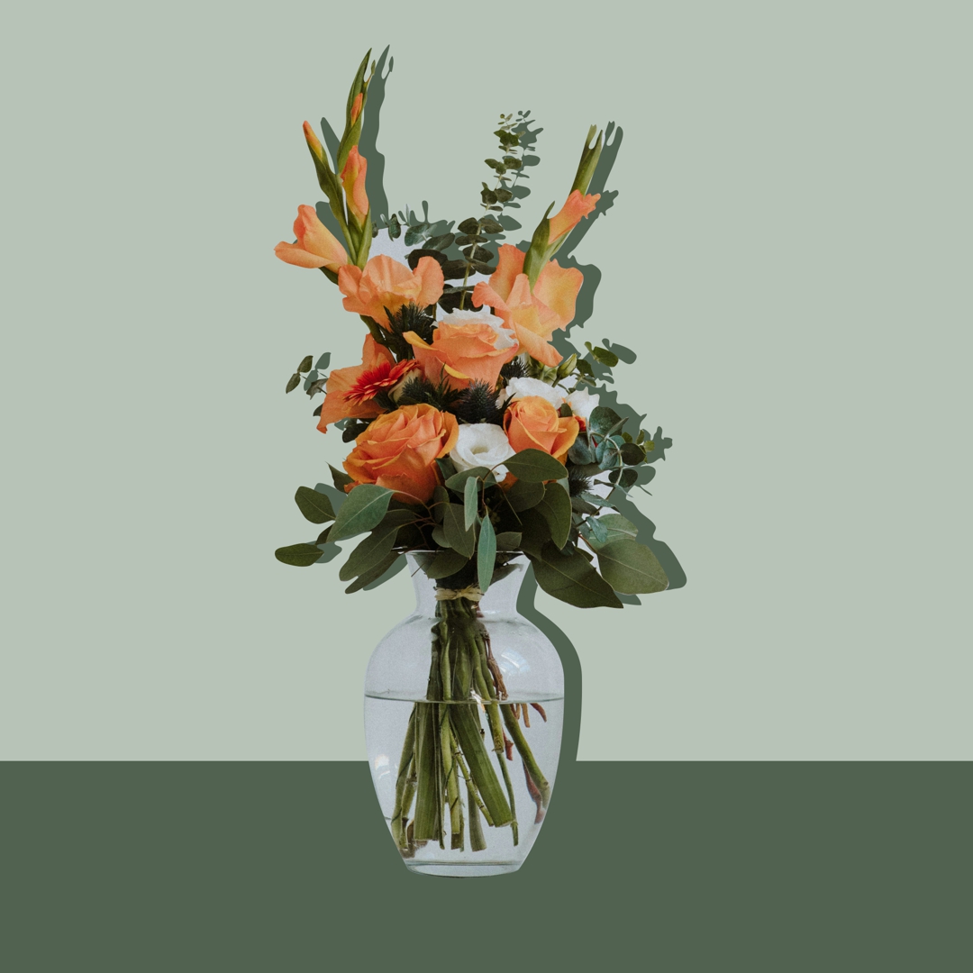 jarrón alargado transparente con flores